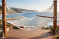 Classic cotton rope hammock with spreader bars hanging between cedar trees