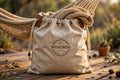 Hammock storage and carry bag beside a folded woven hammock