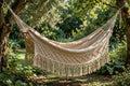 Nicaraguan single hammock in natural woven cotton with fringe in a green garden