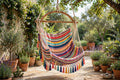 Yucatán hammock chair in striped woven cotton hanging over a garden patio